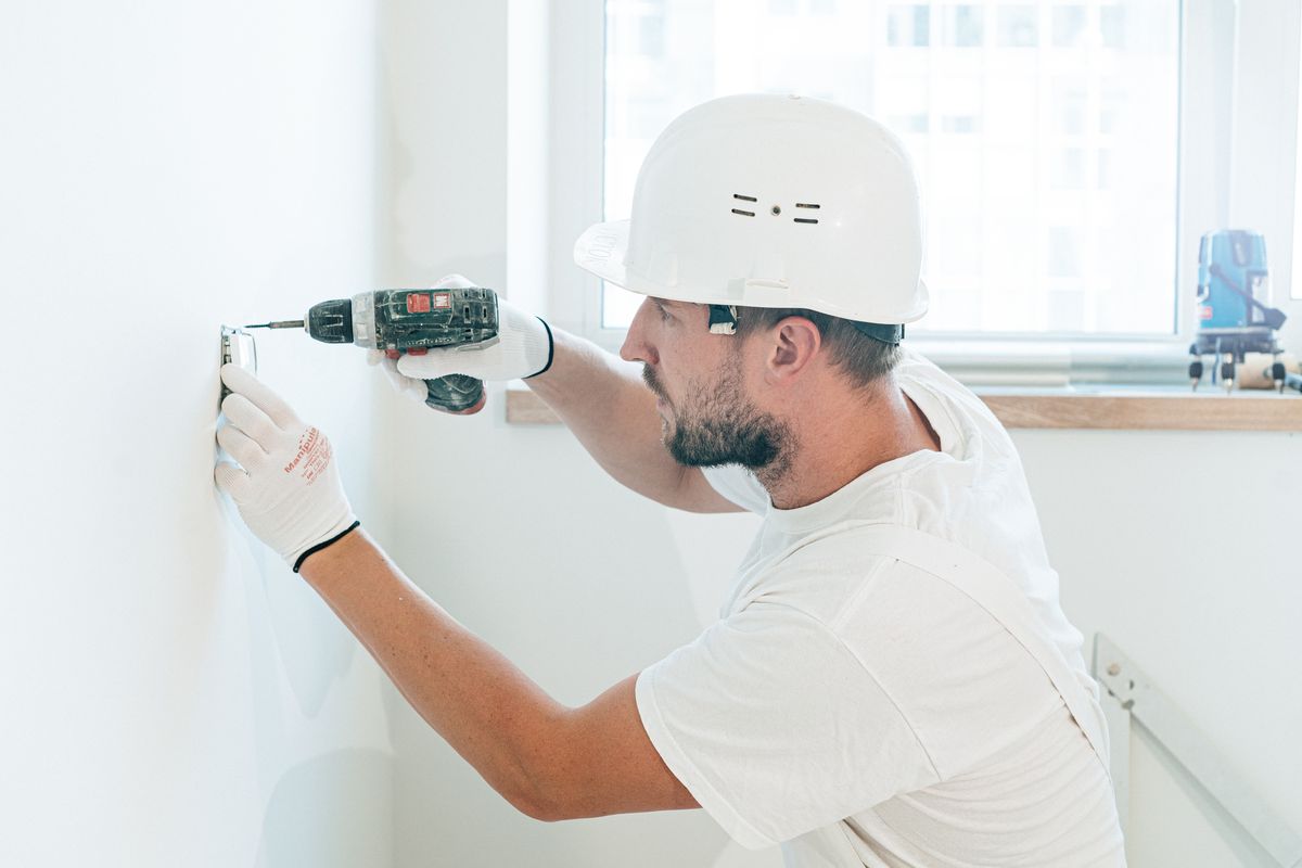 Ouvrier perçant un mur à la perceuse